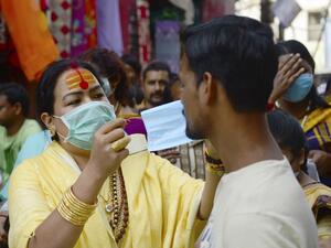 A member of the transgender community distributes free facemask amid concerns over the spead of the COVID-19 coronavirus, at a market area in Allahabad on March 19, 2020. SANJAY KANOJIA / AFP