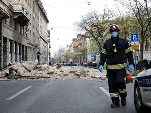 A Croatian fireman walks past rubbles laying on the ground, in a street of downtown Zagreb, on March 22, 2020, after an earthquake hit the country at 06:00 am (0500 GMT). A 5.3-magnitude earthquake shook the Croatian capital of Zagreb on March 22, 2020, damaging buildings and cutting electricity in a number of neighbourhoods. Damir SENCAR / AFP