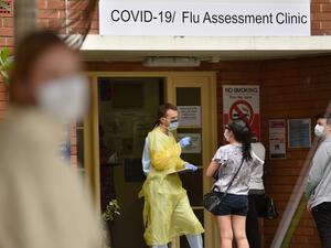 A health worker talks to visitors at a Covid-19 testing centre in Sydney on March 23, 2020. With the imminent closure of pubs, restaurants, cafes and entertainment venues in Sydney, large queues formed outside Australian unemployment benefit offices as online services crashed as the prime minister warned the coronavirus pandemic would cause an economic crisis akin to the Great Depression. PETER PARKS / AFP