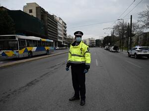 A Greek police officer stands in a deserted street of Athens to control motorists and pedestrians, on March 23, 2020 as the country is battling hard to control the spread of the COVID-19, the novel coronavirus. Aris MESSINIS / AFP