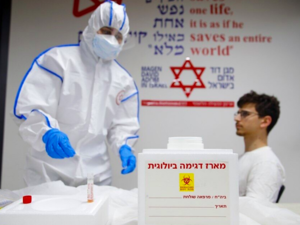 A Magen David Adom paramedic performs a coronavirus test on a volunteer at the coronavirus national operations center in Kiryat Ono, February 26, 2020. (Jack Guez/AFP)