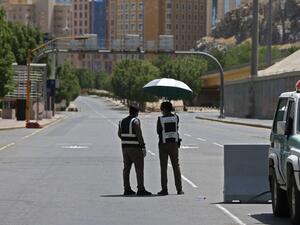 Police officers man a checkpoint in a street in Saudi Arabia's holy city of Mecca on April 3, 2020. Saudi Arabia on April 2 extended curfew restrictions on Islam's two holiest cities to 24 hours to stem the spread of coronavirus as the number of deaths from the disease rose to 21. AFP