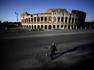 A man walks his dog in front of the Colosseum in central Rome, on April 3, 2020 during the country's lockdown aimed at curbing the spread of the COVID-19 infection, caused by the novel coronavirus. Filippo MONTEFORTE / AFP