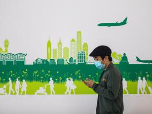 In this picture taken on April 4, 2020, a man wearing a face mask, amid concerns of the COVID-19 coronavirus, walks through the arrivals hall at Hong Kong International Airport. DALE DE LA REY / AFP