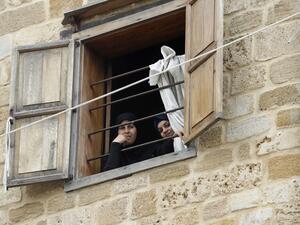 Lebanese women look out of a window during confinement at home due to the COVID-19 pandemic, in the historic part of the southern coastal city of Sidon (Saida), on April 6, 2020. Lebanon's President called on international donors to provide financial assistance to the crisis-hit country as it grapples with a severe economic downturn compounded by the novel coronavirus pandemic. JOSEPH EID / AFP