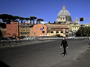 A woman walks with St Peter's Basilica in the background in Rome on April 6, 2020, during the country's lockdown aimed at curbing the spread of the COVID-19 infection, caused by the novel coronavirus. Filippo MONTEFORTE / AFP