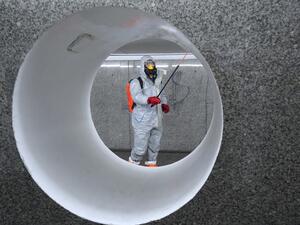Workers wearing protective suits spray disinfectant at the Centrum subway station in Warsaw on April 6, 2020. JANEK SKARZYNSKI / AFP