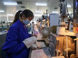 This photo taken on April 6, 2020 shows an employee working at a photoelectric production line at a factory in Wuhan in China's central Hubei province. STR / AFP