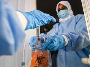 Laboratory workers bag a biological sample at a drive-through COVID-19 coronavirus testing centre in al-Khawaneej district of the gulf emirate of Dubai on April 9, 2020. KARIM SAHIB / AFP