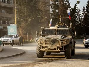 A Russian military police vehicle returning from a joint patrol with Turkish forces along the Syrian-Turkish border, drives along a roundabout near Qamishli airport in the northeastern Syrian city on April 9, 2020. Delil SOULEIMAN / AFP