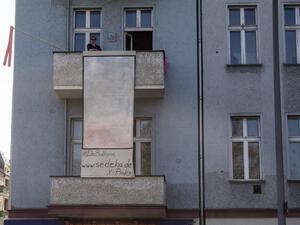 Berlin-based Polish artist Isabella Sedeka stands on her balcony as she displays her work, part of the "Balconies, Life, Art, Pandemic, and Proximity" exhibition, in Berlin on April 12, 2020, amid a new coronavirus COVID-19 pandemic.. AFP/File