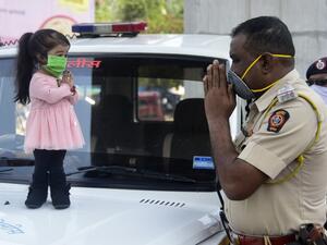 Guinness world record holder of the world's smallest living woman, Jyoti Amge (L), greets a police officer as she appeals citizens to stay inside their homes during a government-imposed nationwide lockdown as a preventive measure against the COVID-19 coronavirus, in Nagpure on April 13, 2020. STR / AFP