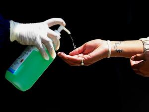 A health worker dispenses sanitizer to a person before a COVID-19 rapid test during a government-imposed nationwide lockdown as a preventive measure against the spread of the COVID-19 coronavirus, in Bungamati, Lalitpur on the outskirts of Kathmandu on April 15, 2020. PRAKASH MATHEMA / AFP