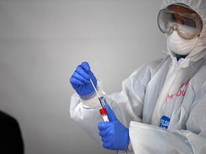 A health worker places a swab in a tube asfter testing a foreign worker for the novel coronavirus at a testing centre in the Naif area of the Gulf Emirate of Dubai, on April 15, 2020. KARIM SAHIB / AFP