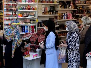 Iranians wearing protective gear amid the COVID-19 pandemic, queue to pay at a shop outside of the Grand Bazaar market in the capital Tehran, on April 18, 2020. Iran allowed some shuttered Tehran businesses to reopen on April 18, despite the Middle East's deadliest coronavirus outbreak, as many faced a bitter choice between risking infection and economic ruin. ATTA KENARE / AFP