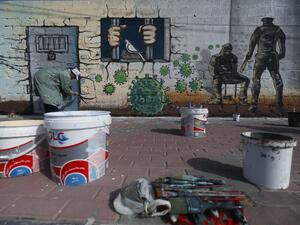 A Palestinian artist paints a mural in a show of support for Palestinian prisoners held in Israeli jails amid the COVID-19 pandemic, in Gaza City on April 20, 2020. Mohammed ABED / AFP