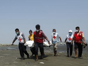 Members of the Myanmar Red Cross carry the body of the driver of a United Nations-marked vehicle after it came under attack while delivering test samples for the COVID-19 coronavirus, in Sittwe, Rakhine State on April 21, 2020. (AFP)