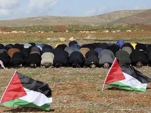 In this file photo taken on January 31, 2020 Palestinian protesters perform the Friday prayer behind national flags during a protest against a US brokered Middle East peace plan, outside the West Bank village of Tamun near the Jordan Valley, on January 31, 2020. Arab foreign ministers are to hold talks on April 30, 2020 on Israel's US-backed plans to annex key parts of the occupied West Bank. Concern has mounted since Israel's right-wing Prime Minister Benjamin Netanyahu -- an outspoken advocate of annexing