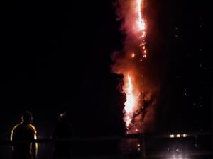 People stand on a bridge and watch a fire that erupts in A 48-Storey Residential Tower in Sharjah on May 5, 2020. AFP People stand on a bridge and watch a fire that erupts in A 48-Storey Residential Tower in Sharjah on May 5, 2020. AFP