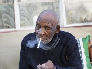 Fredie Blom enjoys a cigarette as he celebrates his 116th birthday at his home in Delft, near Cape Town, on May 8, 2020. According to 'Oupa' (grandfather) Fredie and his identity card, he was born in 1904, making him one of the oldest men in the world. RODGER BOSCH / AFP