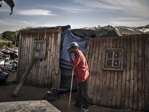 A resident of Plot 323 in Wilgespruit, Johannesburg, pauses on May 08, 2020 in front of a wooden shack during a ministerial visit aimed to ensure that the vulnerable residents of the informal settlement are soon properly accommodated in temporary residential units. MARCO LONGARI / AFP