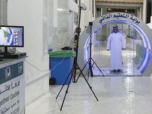 A man passes through a self-sterilisation gate set up at an entrance of the Kaaba and the Grand Mosque, as a preventive measure amid the the COVID-19 pandemic during the Muslim month of Ramadan in the Saudi holy city of Mecca, on May 8, 2020. Saudi Authorities allowed for a limited number of worshippers to enter the Grand Mosque to perform prayers during Ramadan, amid unprecedented bans on family gatherings and mass prayers due to the novel coronavirus (COVID-19) pandemic. STR / AFP