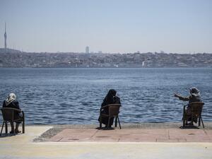 Women wearing protective face masks, sit apart following social distancing measures at the seaside on May 10, 2020, at Kabatas in Istanbul, after a month and a half of lockdown restrictions aimed at stemming the spread of the novel coronavirus, COVID-19. Turkish people aged 65 and over on May 10, 2020, described their joy after the government allowed them to go outside for the first time in nearly two months in an easing of the coronavirus restrictions. While 24 provinces including Ankara and Istanbul are s