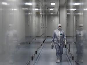 An employee wearing protective equipment walks in a passage at the headquarters of Russia's biotech company BIOCAD, which is developing its own vaccine against the new coronavirus and working on another one in cooperation with the country's virus research centre in Siberia, Vektor, in Strelna on May 20, 2020. OLGA MALTSEVA / AFP
