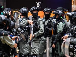 Riot police take part in a crowd dispersal operation in the Central district of Hong Kong on May 27, 2020, as the city's legislature debates over a law that bans insulting China's national anthem. Hong Kong police cast a dragnet around the financial hub's legislature on Wednesday, firing pepper-ball rounds and arresting hundreds as they stamped down on protests against a bill banning insults to China's national anthem. ANTHONY WALLACE / AFP