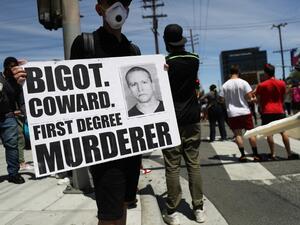 A protestor holds a sign with a photo of former Minneapolis police officer Derek Chauvin during demonstrations following the death of George Floyd on May 30, 2020 in Los Angeles, California. Chauvin was taken into custody for Floyd's death. (MARIO TAMA / GETTY IMAGES NORTH AMERICA / Getty Images via AFP)