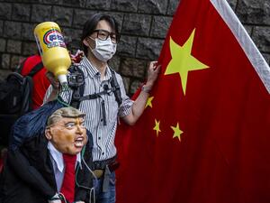 A pro-China activist holds an effigy of US President Donald Trump during a protest outside the US consulate in Hong Kong on May 30, 2020, in response to US President Donald Trump saying on May 29 he would strip several of Hong Kong's special privileges with the United States and bar some Chinese students from US universities in anger over Beijing's bid to exert control in the financial hub. ISAAC LAWRENCE / AFP