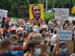 A protester holds up a portrait of George Floyd during a "Black Lives Matter" demonstration in front of the Brooklyn Library and Grand Army Plaza on June 5, 2020 in Brooklyn, New York, amid ongoing protests over Floyd's death in police custody. Angela Weiss / AFP