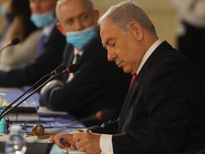 Israeli Prime Minister Benjamin Netanyahu writes during the weekly cabinet meeting in Jerusalem on June 7, 2020. Netanyahu urged world powers to reimpose tough sanctions against Iran, vowing to curb Tehran's regional "aggression" hours after another deadly strike on pro-Iranian fighters in Syria. Menahem KAHANA / AFP