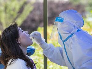 A medical worker takes a swab sample from a student to be tested for the COVID-19 coronavirus at Wuhan University, on the first day of classes in Wuhan on June 8, 2020. Final year students returned to campuses in Wuhan after universities were reopened following a months-long closure due to the coronavirus. STR / AFP