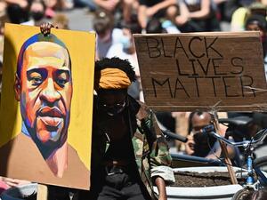 Protesters hold up signs during a "Black Lives Matter" protest in front of Borough Hall on June 8, 2020 in New York City. On May 25, 2020, Floyd, a 46-year-old black man suspected of passing a counterfeit $20 bill, died in Minneapolis after Derek Chauvin, a white police officer, pressed his knee to Floyd's neck for almost nine minutes.  Angela Weiss / AFP