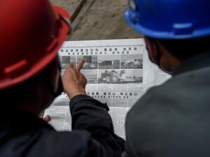 Employees of the Kim Jong Thae Electric Locomotive Complex in Pyongyang read a copy of the Rodong Sinmun newspaper showing coverage of North Korea's demolition of the north-south joint liaison office, on June 17, 2020. North Korea's spectacular destruction of its liaison office with the South is part of a series of staged provocations aimed at forcing concessions from Seoul and Washington, analysts say. KIM Won Jin / AFP