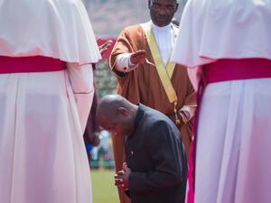 Burundi's elected President Evariste Ndayishimiye (C) prays on his knees with Burundi's religious leaders during the inauguration ceremony at Ingoma stadium in Gitega, Burundi, on June 18, 2020. Ndayishimiye rapidly sworn in following the sudden death of President Pierre Nkurunziza, aged 55, came after the May election. TCHANDROU NITANGA / AFP