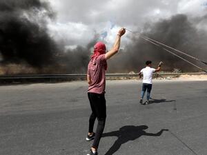 A Palestinian demonstrator uses a slingshot to hurl rocks at Israeli troops during a protest against Israel's plan to annex parts of the occupied West Bank, near the city of Ramallah, on June 19, 2020. Israel intends to annex West Bank settlements and the Jordan Valley, as proposed by US President Donald Trump, with initial steps slated to begin from July 1. ABBAS MOMANI / AFP