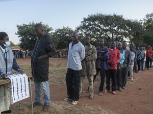An electoral official (L) checks the voters' roll while people queue to vote at the Malembo polling station during the presidential elections in Lilongwe on June 23, 2020. Malawians return to the polls on June 23, 2020 for the second time in just over a year to vote for a new president after Peter Mutharika's re-election was annulled over rigging. The election is much anticipated after the Constitutional Court early this year ruled that the May 2019 vote, won narrowly by Mutharika, was fraught with "grave a