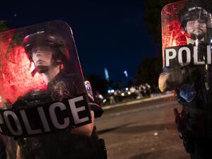 Policemen look through their shields as they and others members of their team are keeping protesters from entering Lafayette Park near the White House, in Washington, DC on June 22, 2020. A crowd of protestors tried to topple the statue of former US president General Andrew Jackson near the White House in the evening of June 22 as police responded with pepper spray to break up new demonstrations that erupted in Washington. ROBERTO SCHMIDT / AFP