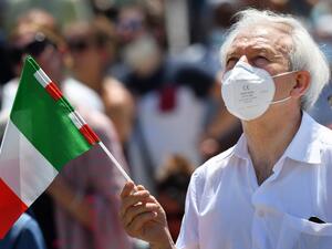 A man wearing a face mask and holding the Italian flag attends the Pope's weekly Angelus prayer at St. Peter's Square in The Vatican, on June 28, 2020 as the city-state eases its lockdown aimed at curbing the spread of the COVID-19 infection, caused by the novel coronavirus. Alberto PIZZOLI / AFP