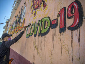 A Moroccan artist works on a mural thanking essential workers amid the COVID-19 pandemic, in the city of Sale north of the capital. (File/AFP)