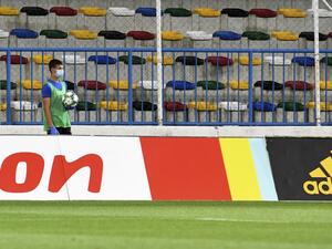 A ball boy wearing a protective mask stands in front of empty grandstand during the football match between FC Lokomotiva and FC Osijek in Zagreb.