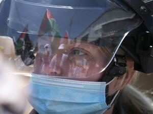 A Palestinian flag is reflected on the helmet of an Israeli border guard wearing a mask against Covid-19 as forces keep watch while Palestinians perform Friday prayer during a protest against Israel's plan to annex parts of the occupied West Bank, in the Palestinian village of Haris, southwest of Nablus, on June 26, 2020. JAAFAR ASHTIYEH / AFP