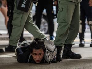 Riot police detain a man as they clear protesters taking part in a rally against a new national security law in Hong Kong on July 1, 2020, on the 23rd anniversary of the city's handover from Britain to China. Hong Kong police made the first arrests under Beijing's new national security law on July 1 as the city greeted the anniversary of its handover to China with protesters fleeing water cannon. DALE DE LA REY / AFP
