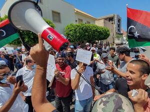Libyans lift placards at a rally in front of the Prime Ministers headquarters in the capital Tripoli to protest frequent electricity cuts, on July 1, 2020. Mahmud TURKIA / AFP