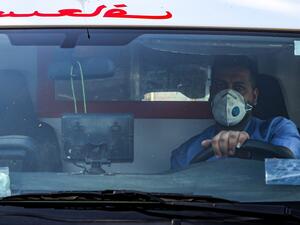 A mask-clad driver sits behind the wheel in an ambulance in the central Karrada district of Iraq's capital Baghdad on July 1, 2020. AFP