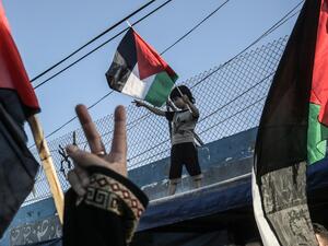 A Palestinian boy waves a national flag during a demonstration against Israel's West Bank annexation plans, in Khan Yunis in the southern Gaza Strip on July 2, 2020. SAID KHATIB / AFP