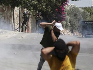 Palestinian protesters run for cover as Israeli troops fire tear gas towards the crowd during a demonstration in the village of Kfar Qaddum in the occupied West Bank against the Jewish state's plans to annex part of the Palestinian territory on July 3, 2020. Rival Palestinian factions Fatah and Hamas pledged the previous day a united campaign against Israel's prospective plans to annex territory in the occupied West Bank, in a rare joint press conference, spurred by their common opposition to US President D