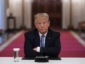 US President Donald Trump sits with his arms crossed during a roundtable discussion on the Safe Reopening of America’s Schools during the coronavirus pandemic, in the East Room of the White House on July 7, 2020, in Washington, DC. JIM WATSON / AFP